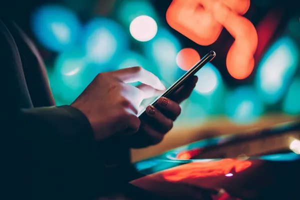 Uma mulher glamourosa segurando fichas de cassino em um ambiente iluminado por néon, representando a atmosfera premium do cassino online 25F.